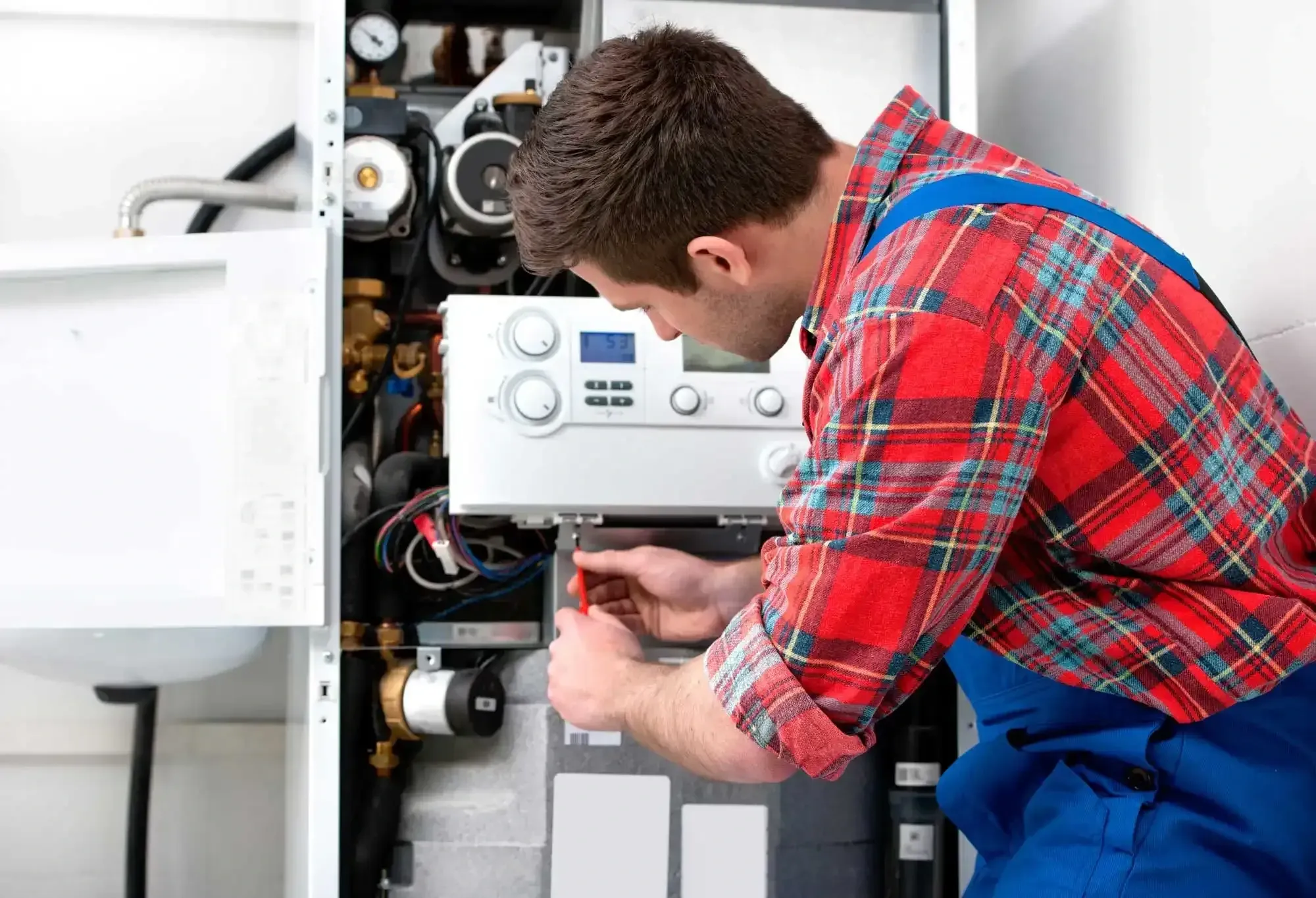 HVAC technician servicing a wall-mounted gas heating unit during a furnace repair in Princeton, TX