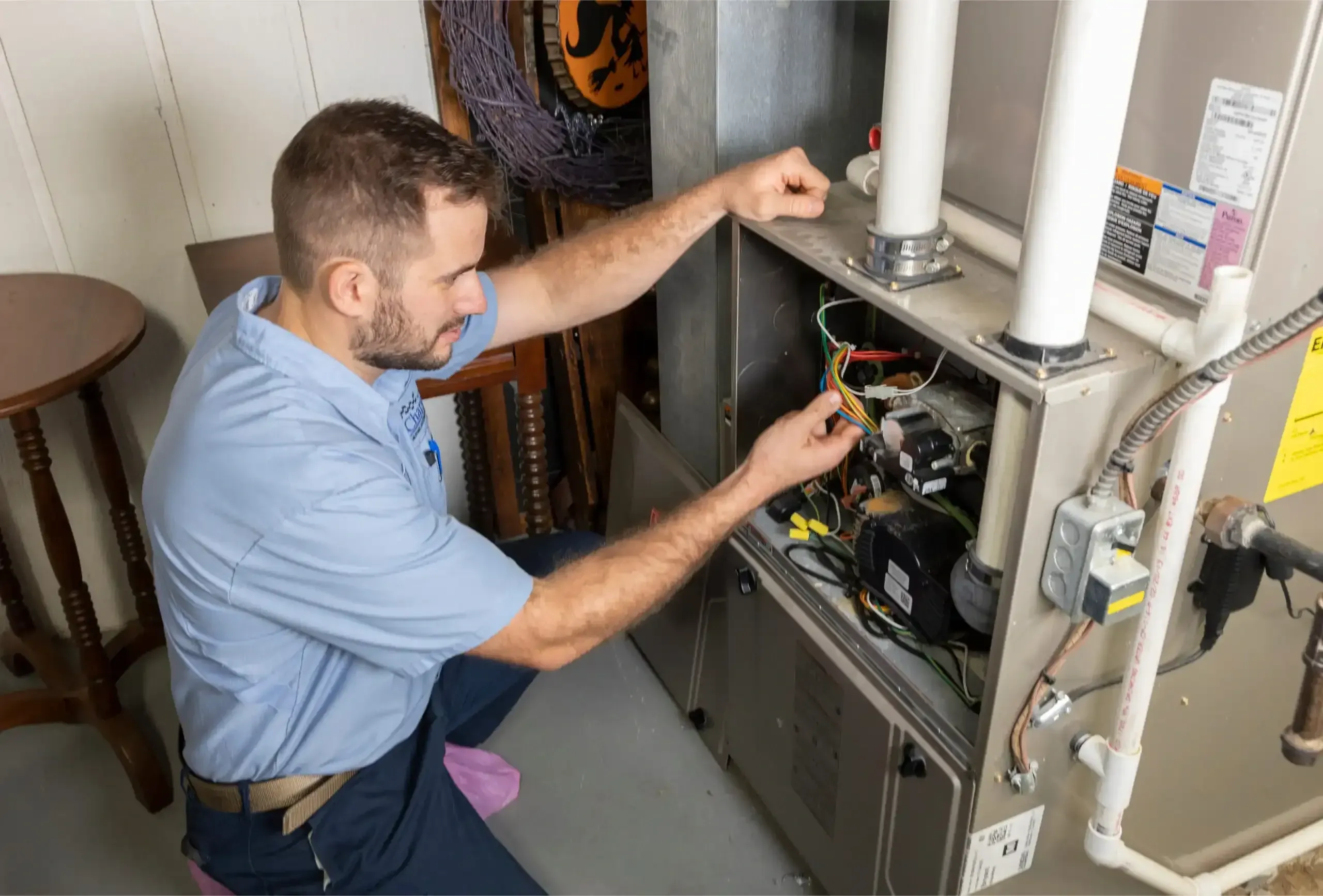 Technician working inside an open gas furnace cabinet during a furnace replacement in Allen, TX