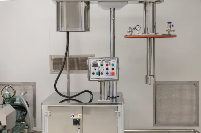 Stainless steel laboratory equipment with control panel, in a white-walled room.
